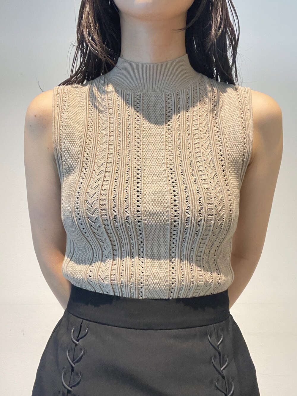 ベージュ系のニット/セーター、ベージュ系のブーツ、ブラック系のスカートを着用したレディースの夏コーディネートの7枚目の写真