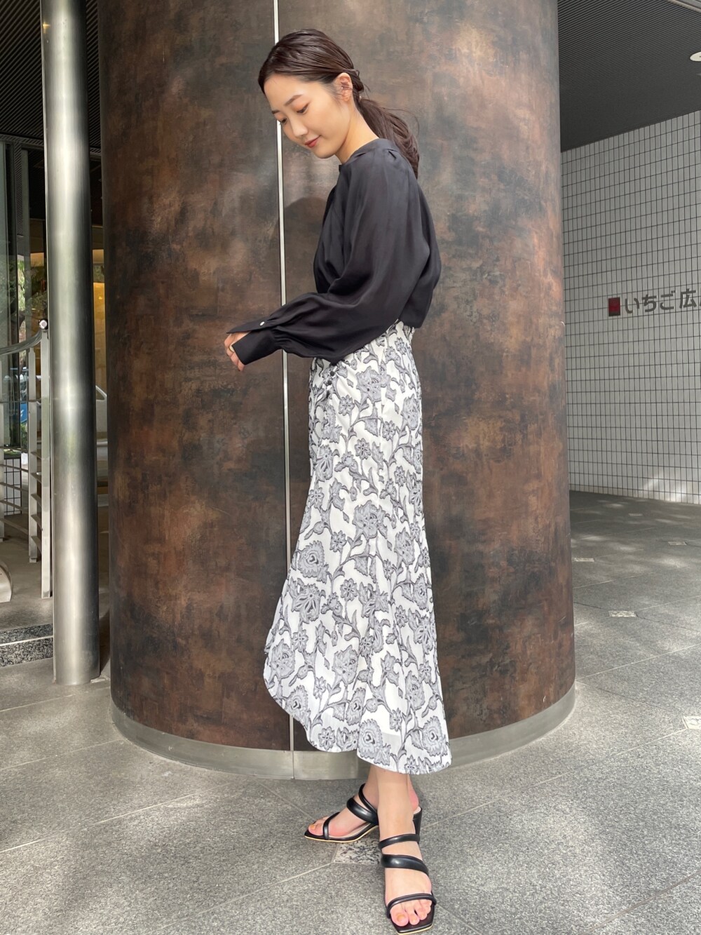 ベージュ系のサンダル、ブラック系のスカート、ブラック系のシャツ/ブラウスを着用したレディースの冬コーディネートの4枚目の写真