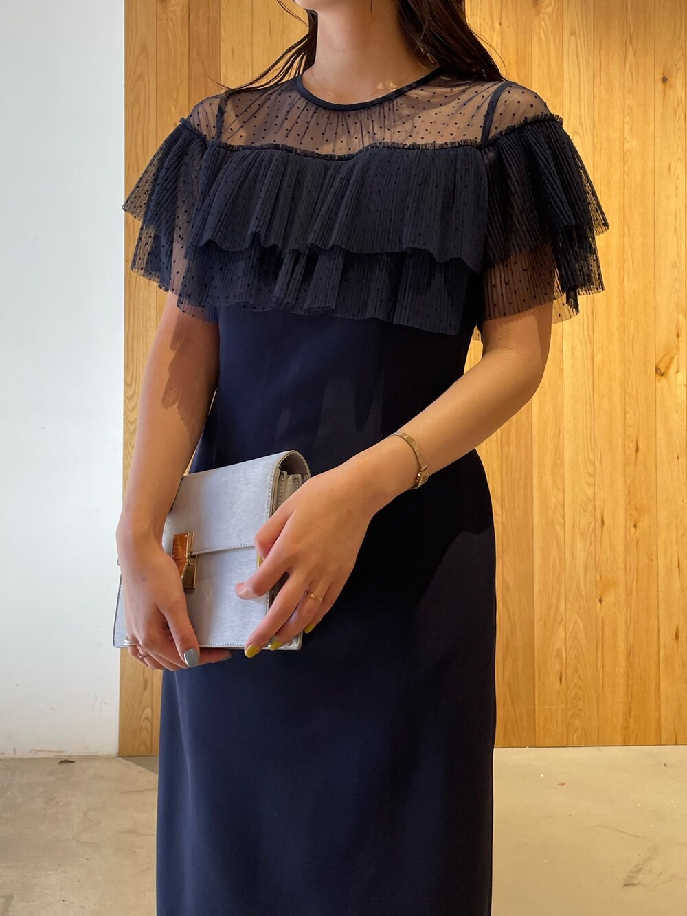 グレー系のパンプス、グレー系のクラッチバッグ、ブルー系のドレスを着用したレディースの冬コーディネートの7枚目の写真