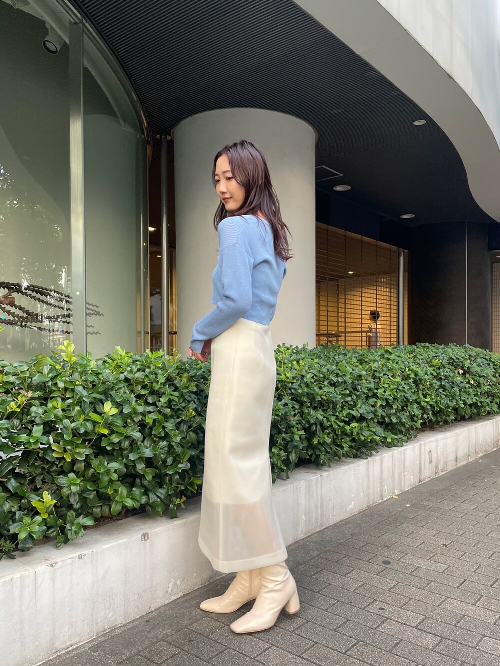 ホワイト系のブーツ、ホワイト系のスカート、ブルー系のカーディガン/ボレロを着用したレディースの秋コーディネートの4枚目の写真