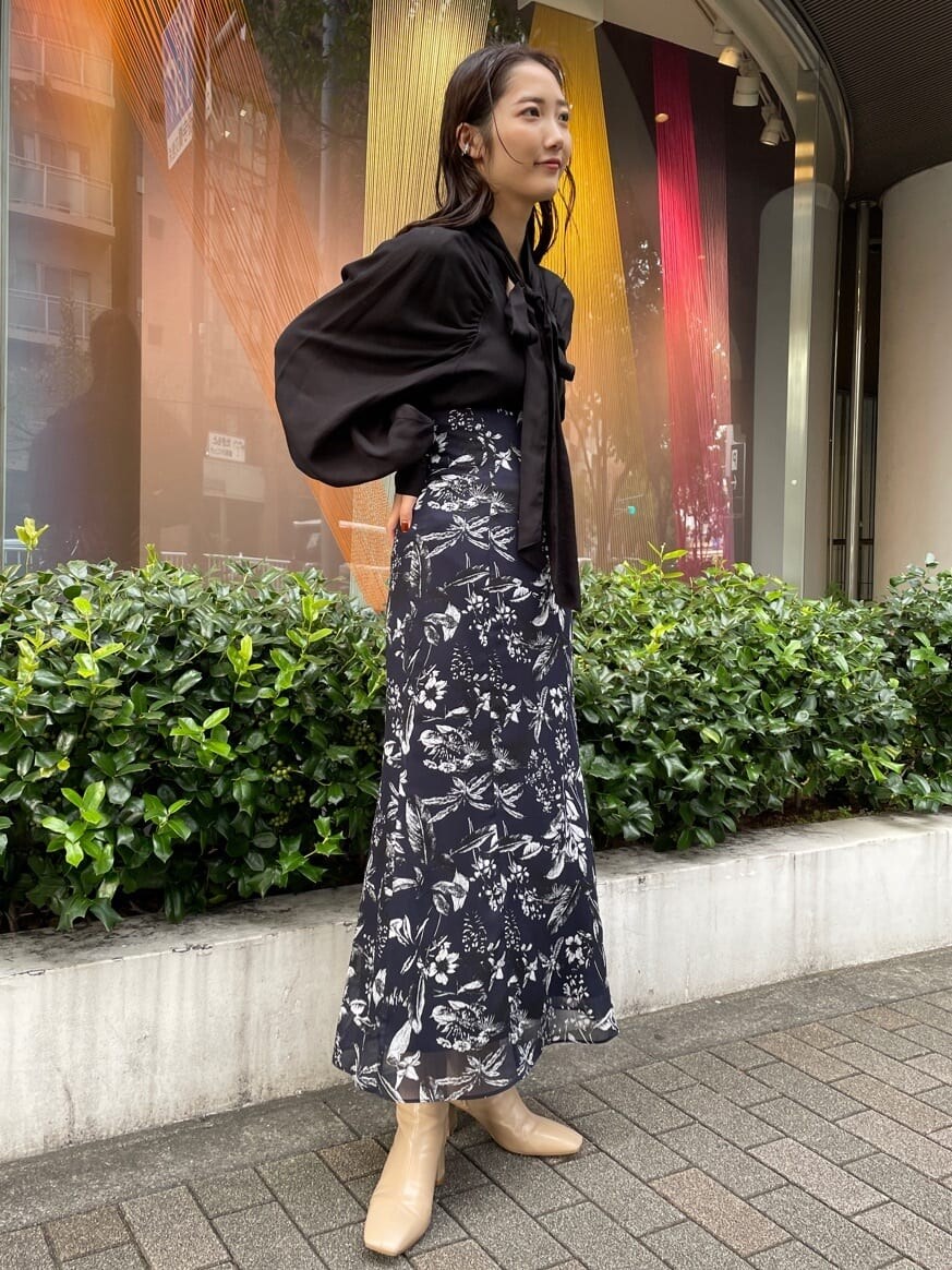 ブラック系のシャツ/ブラウス、ブルー系のスカート、ブルー系のスカートを着用したレディースの秋コーディネートの3枚目の写真