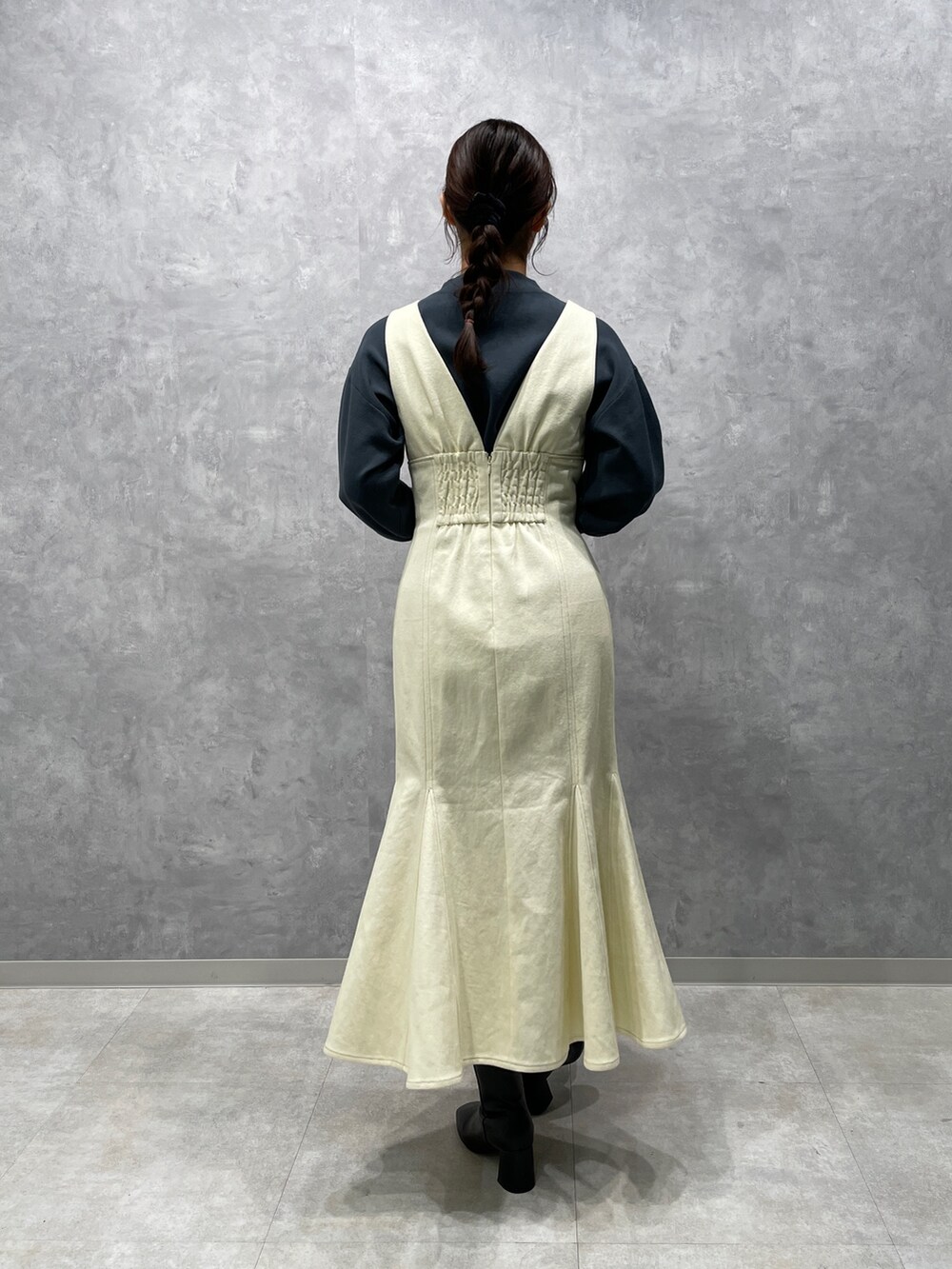 グリーン系のニット/セーター、ホワイト系のカーディガン/ボレロ、ブラック系のブーツを着用したレディースの冬コーディネートの7枚目の写真