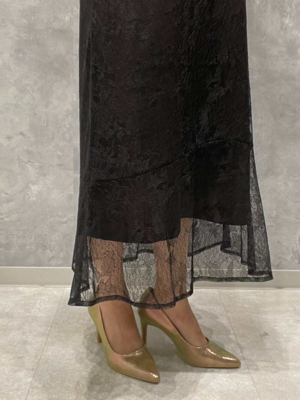 ゴールド系のパンプス、ゴールド系のハンドバッグ、ブラック系のドレスを着用したレディースの秋コーディネートの9枚目の写真