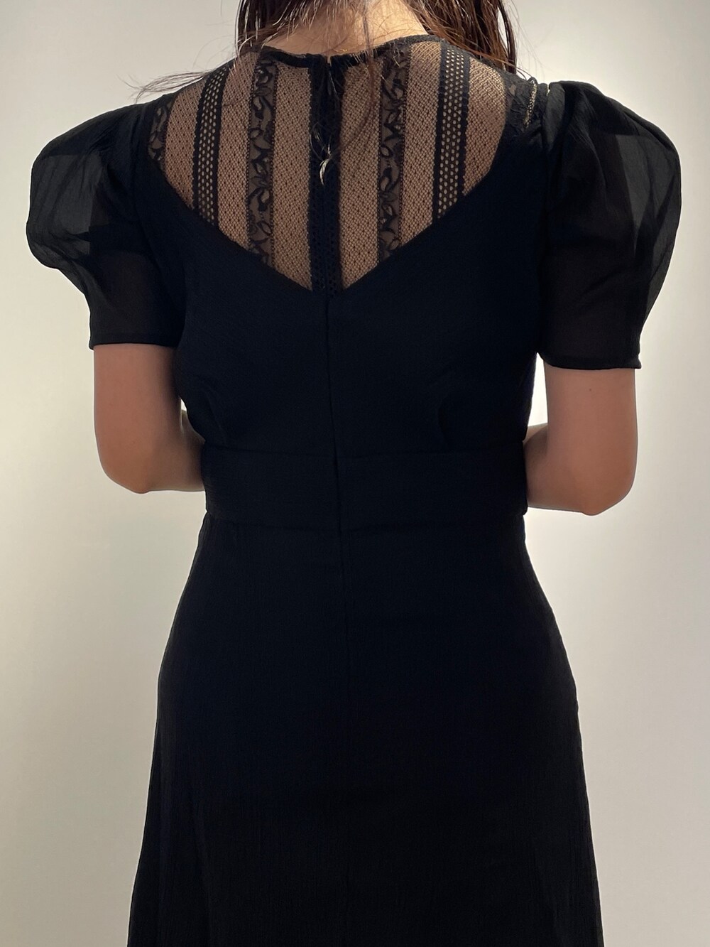 ブラック系のドレス、ブラック系のブーツを着用したレディースの冬コーディネートの7枚目の写真