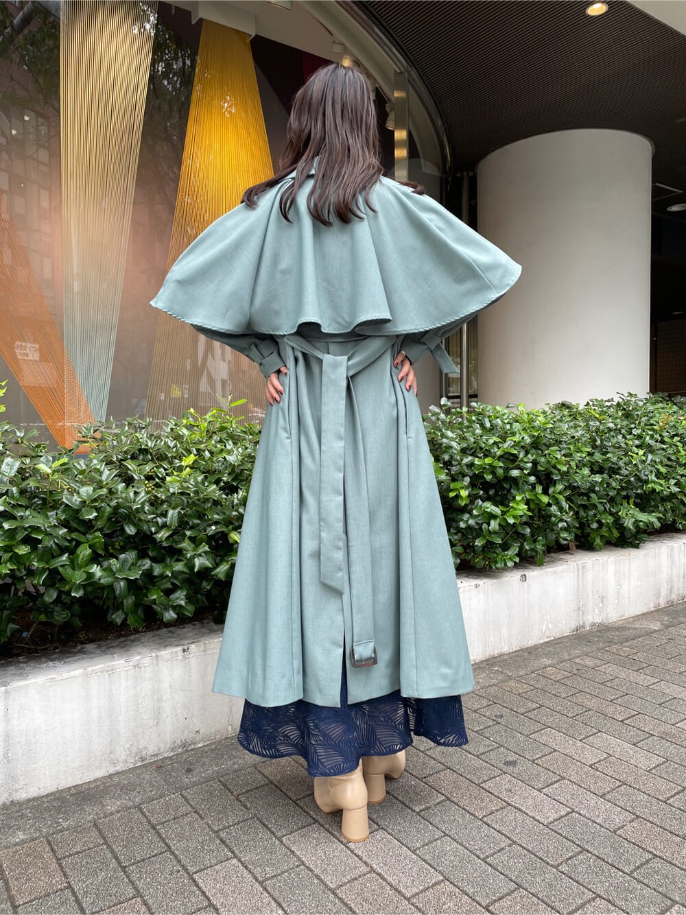 ブルー系のトレンチコート、ブルー系のトレンチコート、ベージュ系のブーツを着用したレディースの秋コーディネートの3枚目の写真