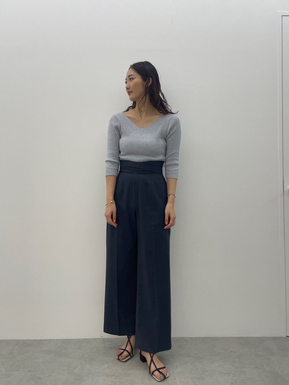 ブラック系のサンダル、ブルー系のスラックス、ブルー系のニット/セーターを着用したレディースの春コーディネートの6枚目の写真