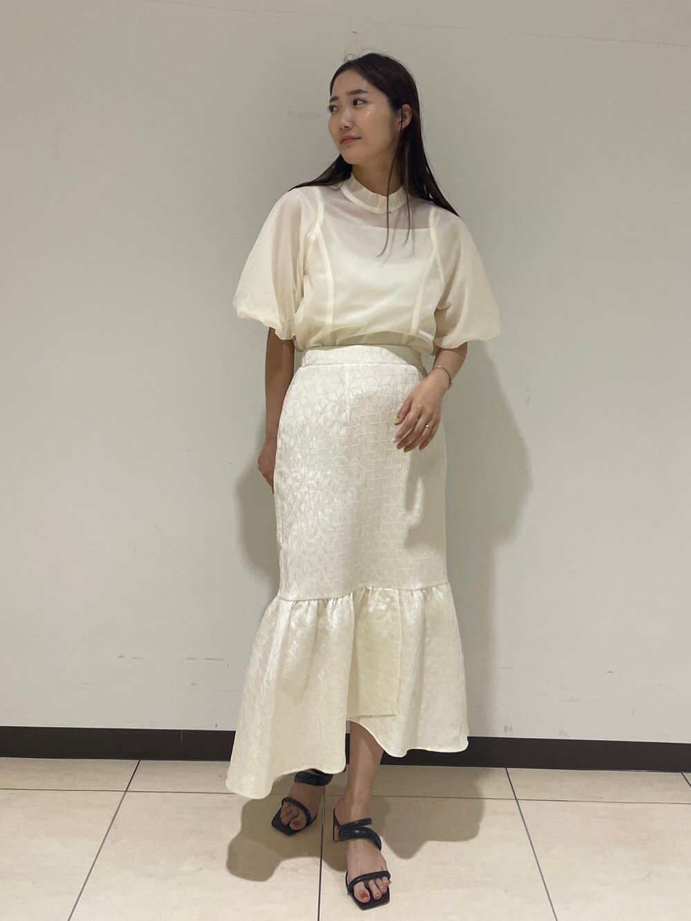 ホワイト系のシャツ/ブラウス、ホワイト系のスカート、ブラック系のサンダルを着用したレディースの春コーディネートの4枚目の写真