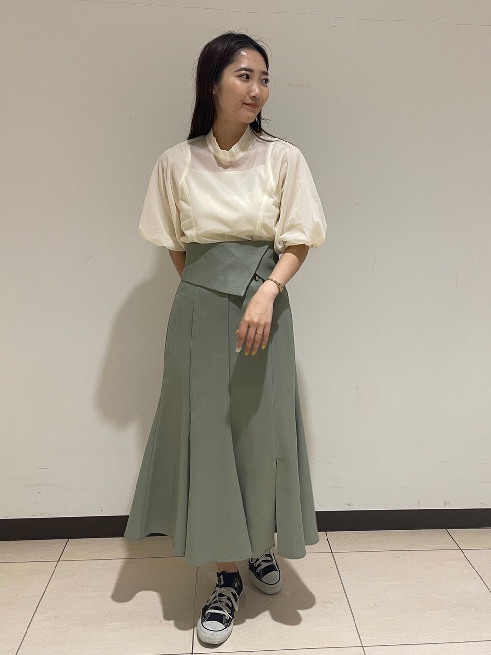 グリーン系のスカート、ホワイト系のシャツ/ブラウスを着用したレディースの春コーディネートの2枚目の写真