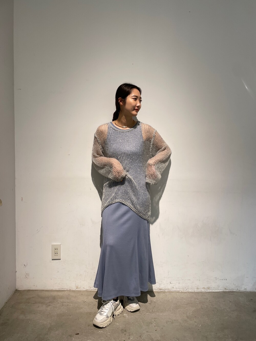 ホワイト系のスニーカー、ブルー系のニット/セーター、ブルー系のワンピースを着用したレディースの春コーディネートの3枚目の写真