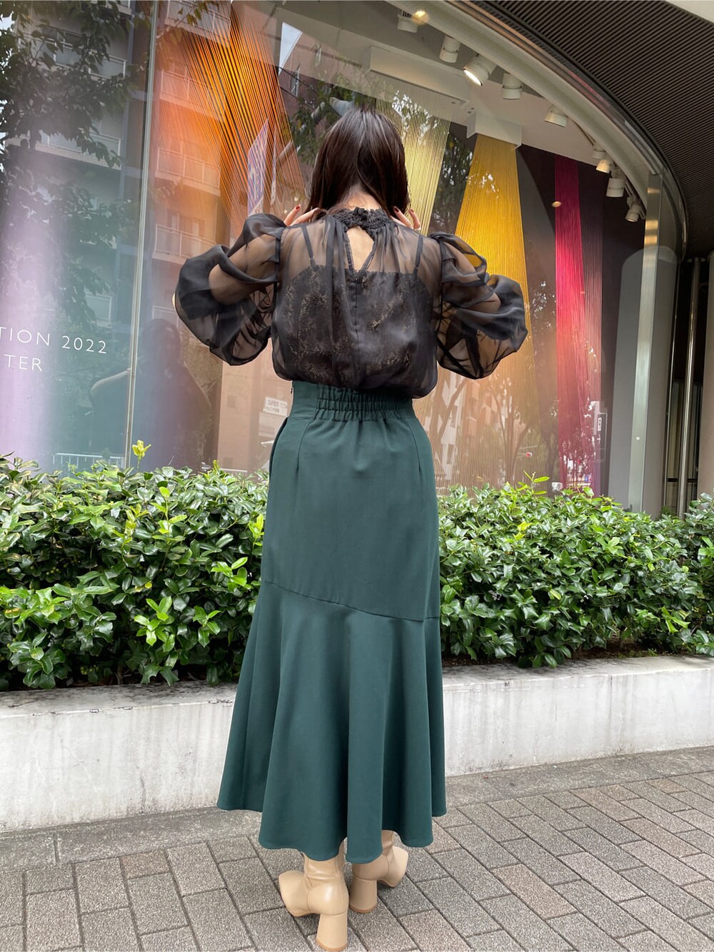 ベージュ系のトレンチコート、グリーン系のスカート、ベージュ系のトレンチコートを着用したレディースの秋コーディネートの7枚目の写真