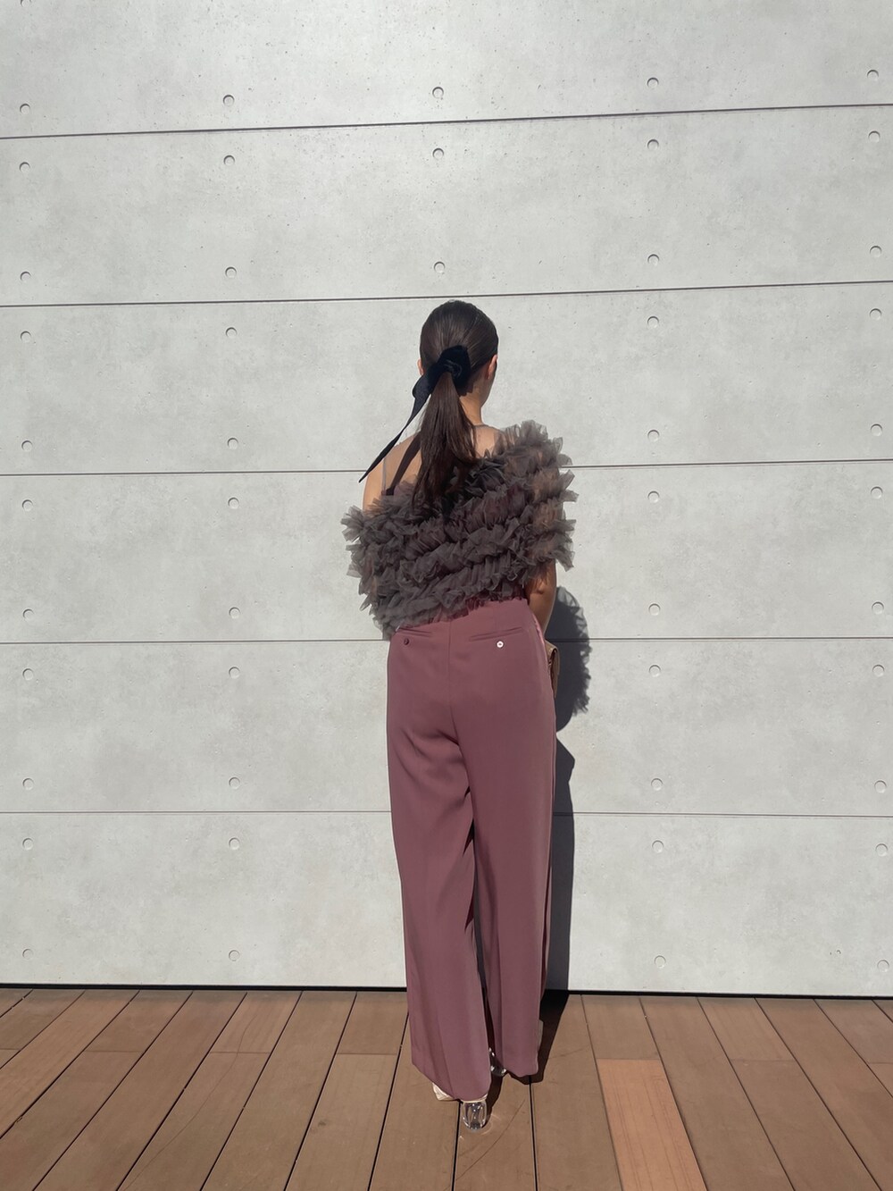 ピンク系のパンツドレス、ゴールド系のハンドバッグ、ベージュ系のパンプスを着用したレディースの秋コーディネートの9枚目の写真