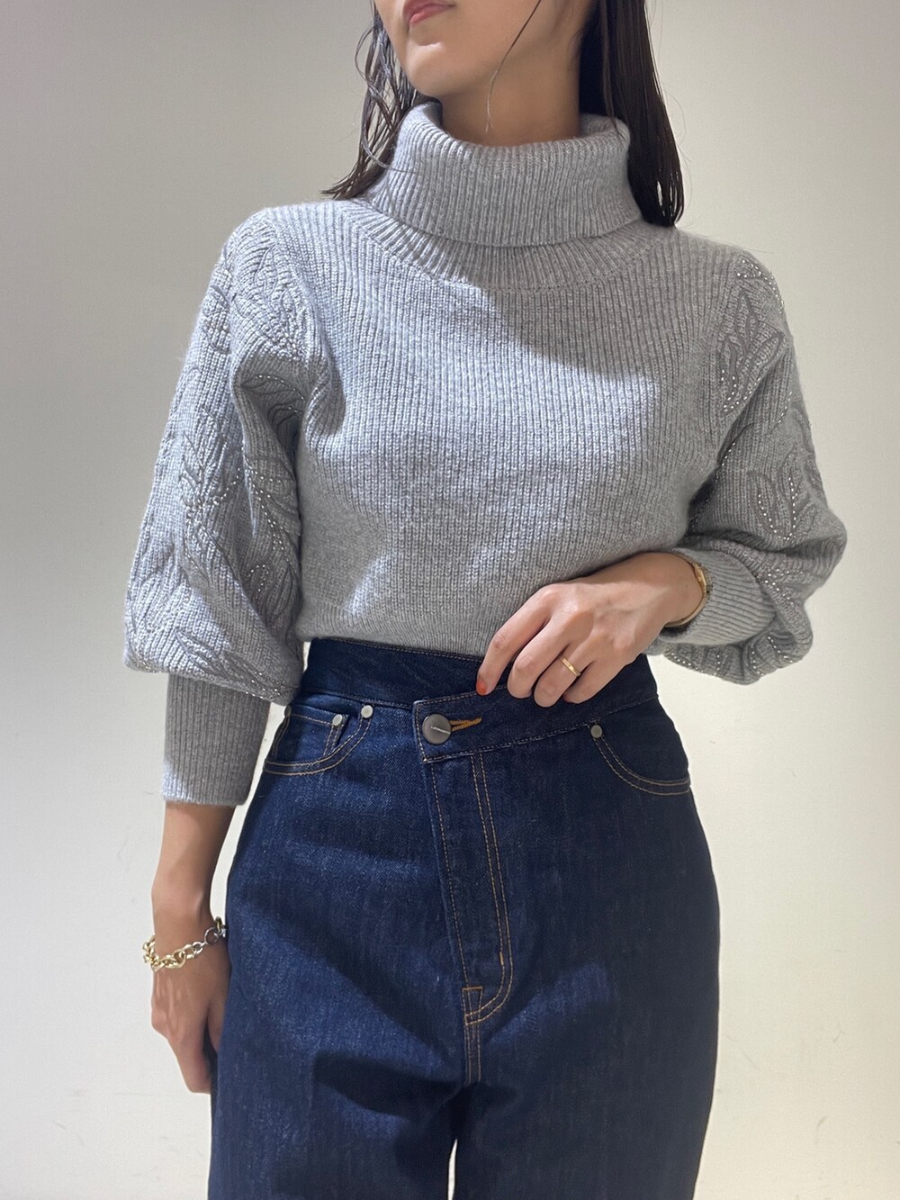 ブラック系のブーツ、ブルー系のデニムパンツ、グレー系のニット/セーターを着用したレディースの秋コーディネートの8枚目の写真