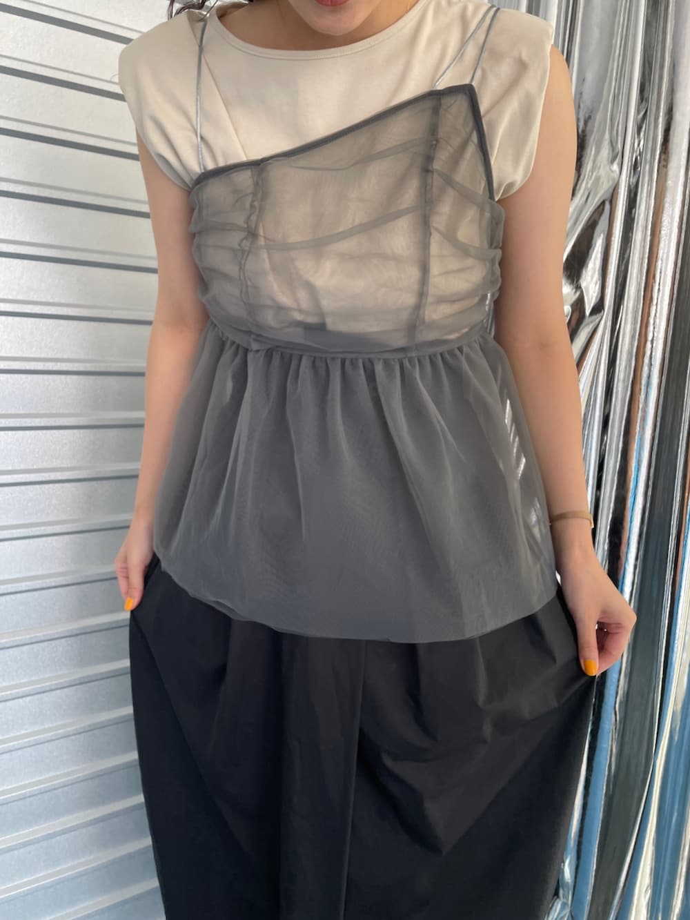 ブラック系のサンダル、ブラック系のスカート、ベージュ系のTシャツ/カットソーを着用したレディースの夏コーディネートの6枚目の写真