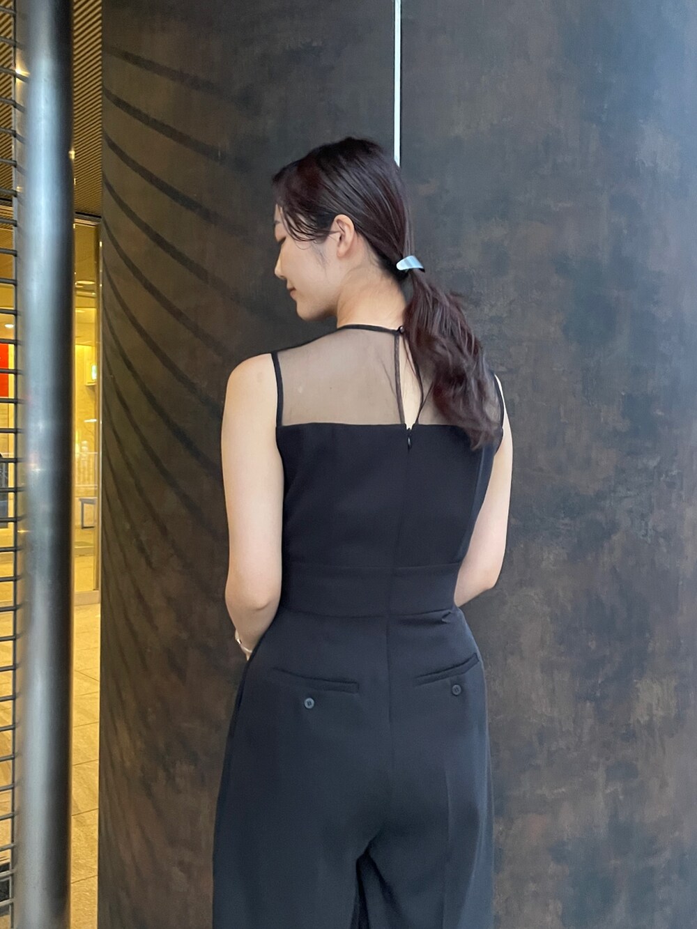 ブラック系のパンプス、ブラック系のパンツドレスを着用したレディースの秋コーディネートの9枚目の写真