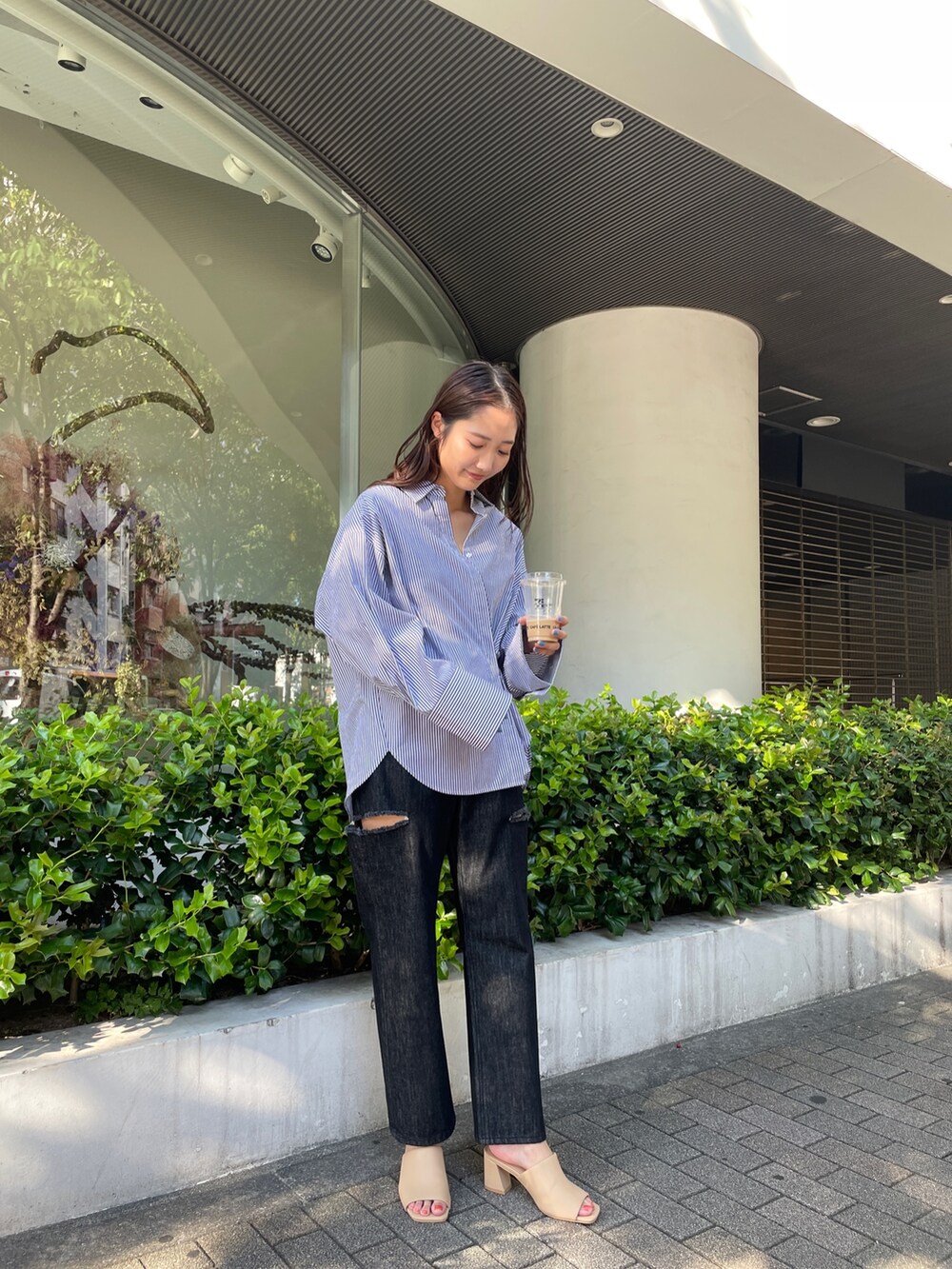 ブラック系のデニムパンツ、ベージュ系のサンダル、ブラック系のシャツ/ブラウスを着用したレディースの夏コーディネートの3枚目の写真