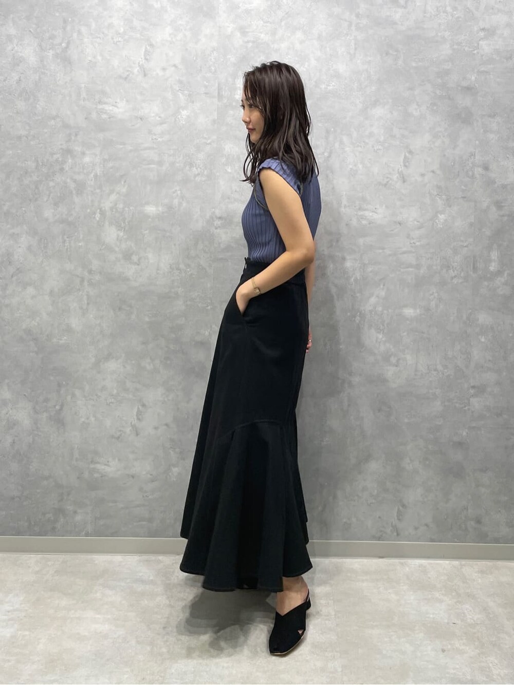 ブラック系のサンダル、ブラック系のスカート、ブルー系のニット/セーターを着用したレディースの夏コーディネートの3枚目の写真