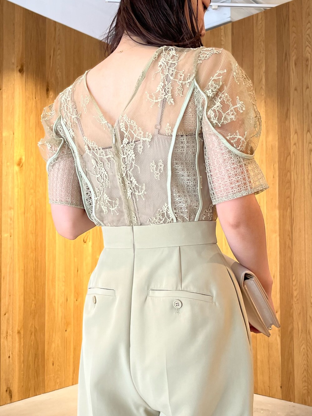 ベージュ系のパンプス、ベージュ系のクラッチバッグ、グリーン系のパンツドレスを着用したレディースの冬コーディネートの7枚目の写真