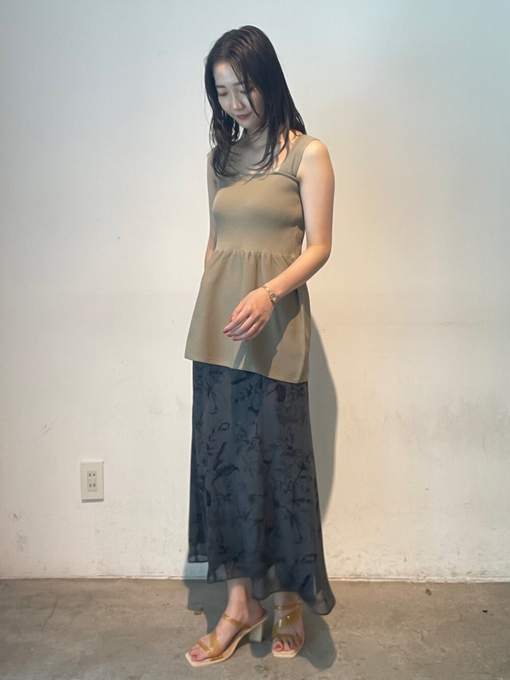 グレー系のスカート、イエロー系のサンダル、ベージュ系のニット/セーターを着用したレディースの夏コーディネートの3枚目の写真