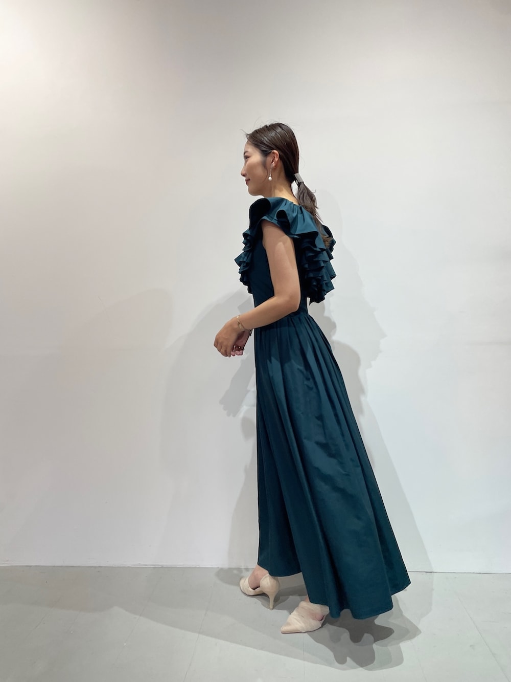 ベージュ系のパンプス、グリーン系のドレス、シルバー系のバレッタ/ヘアクリップを着用したレディースの夏コーディネートの3枚目の写真