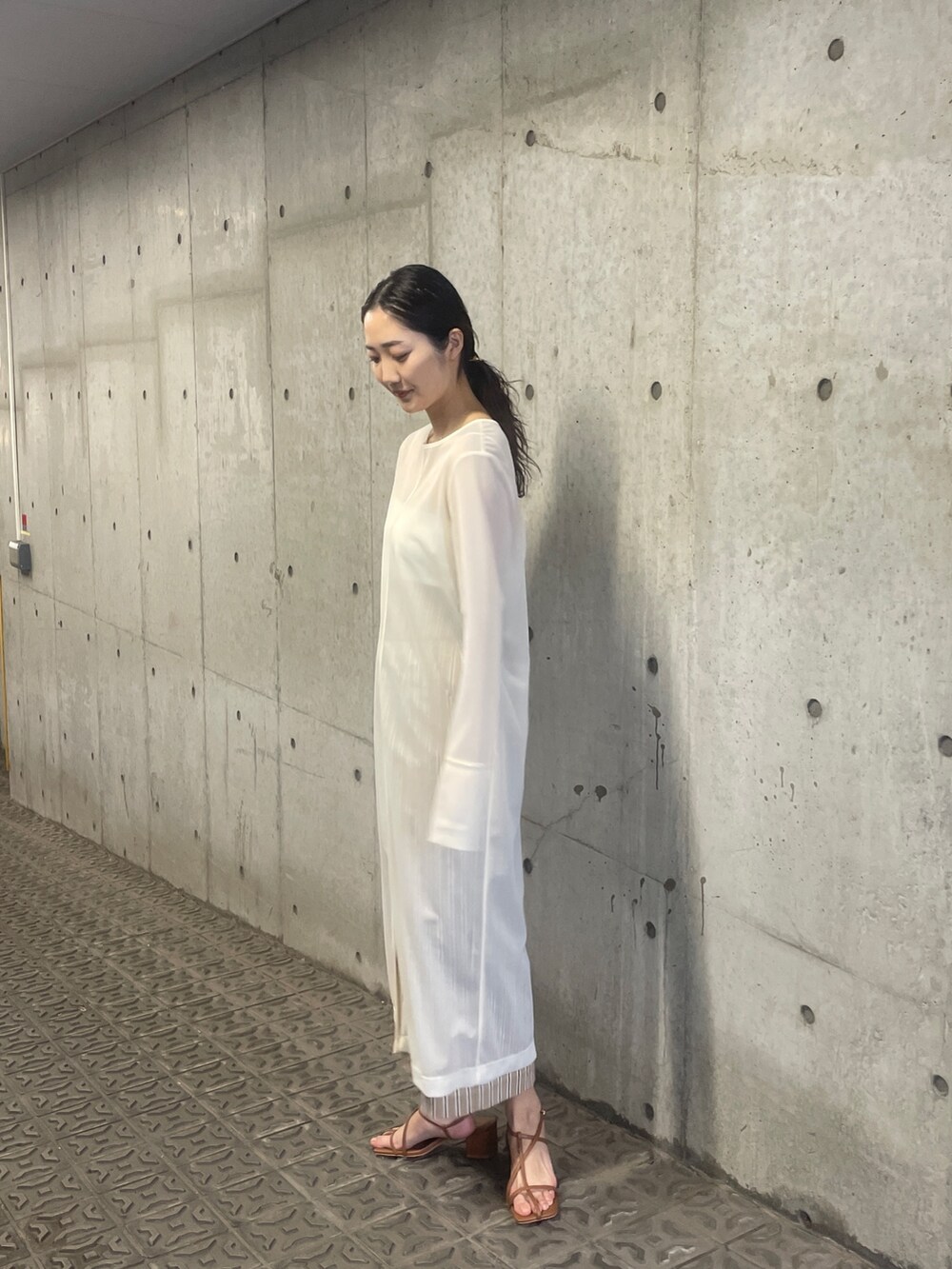 ホワイト系のTシャツ/カットソー、ベージュ系のスカート、ブラウン系のサンダルを着用したレディースの春コーディネートの6枚目の写真