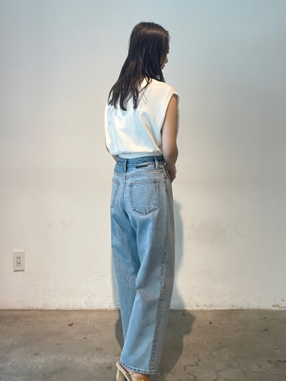 ブルー系のデニムパンツ、ホワイト系のニット/セーター、イエロー系のサンダルを着用したレディースの夏コーディネートの5枚目の写真