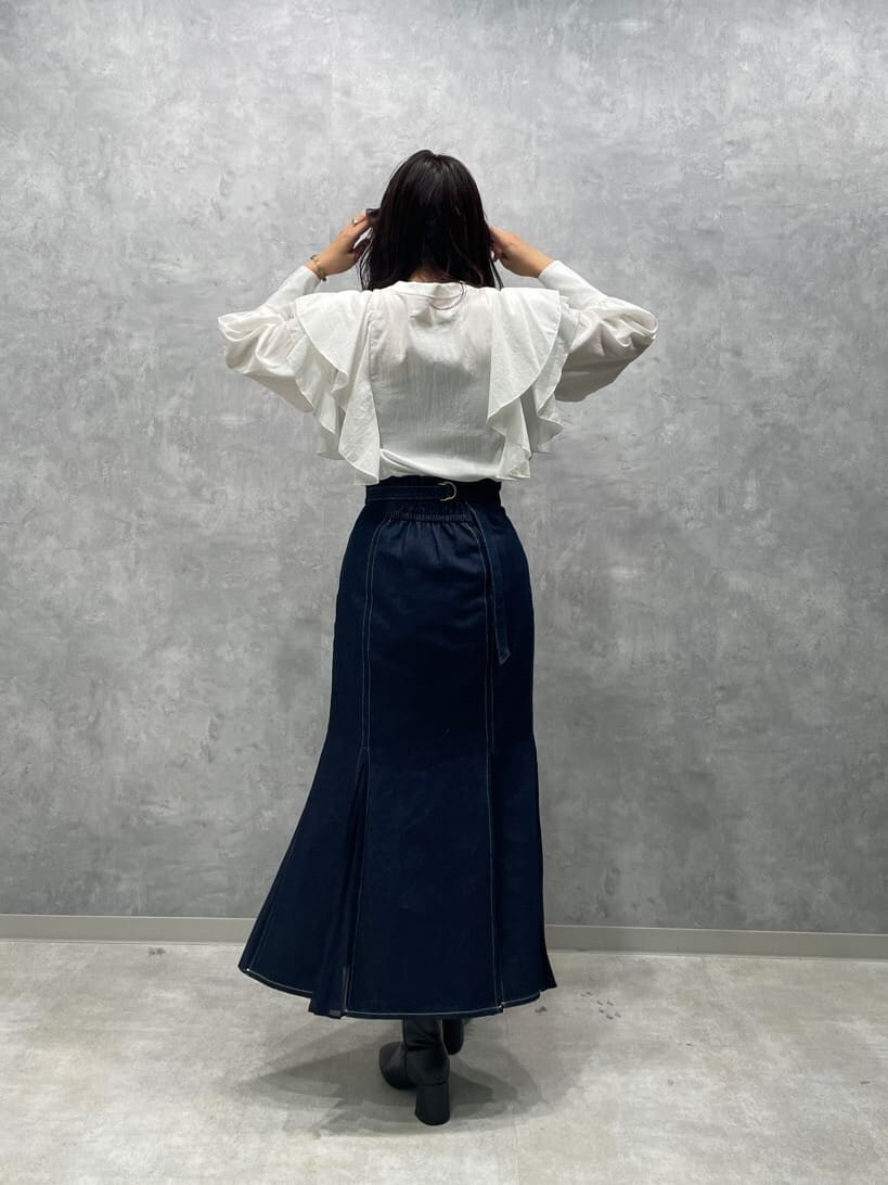 ブラック系のブーツ、ブルー系のスカート、ホワイト系のシャツ/ブラウスを着用したレディースの秋コーディネートの6枚目の写真