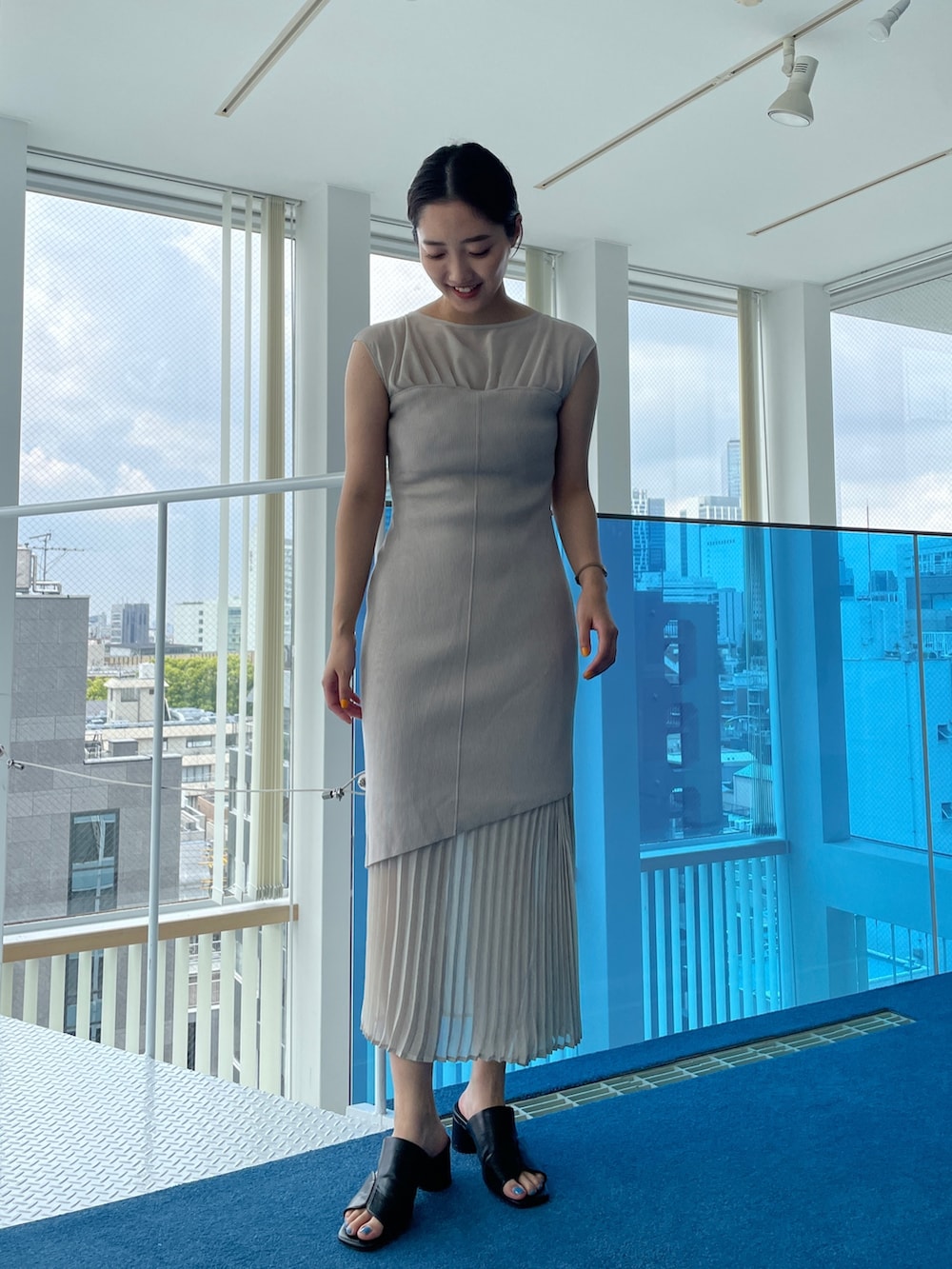 ブラック系のサンダル、ベージュ系のワンピースを着用したレディースの春コーディネートの6枚目の写真