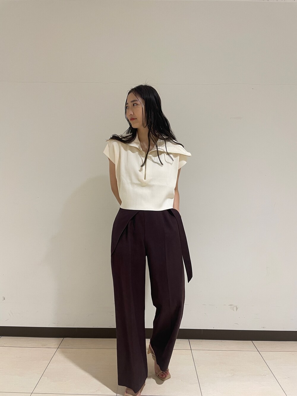 ブラウン系のその他パンツ、ホワイト系のニット/セーター、ベージュ系のサンダルを着用したレディースの春コーディネートの3枚目の写真