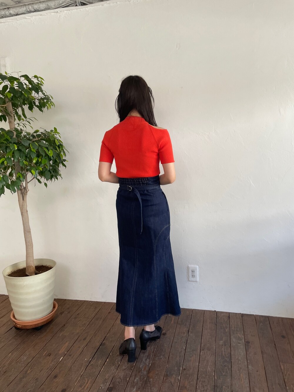 オレンジ系のニット/セーター、ブルー系のデニムスカート、ブラック系のパンプスを着用したレディースの春コーディネートの4枚目の写真