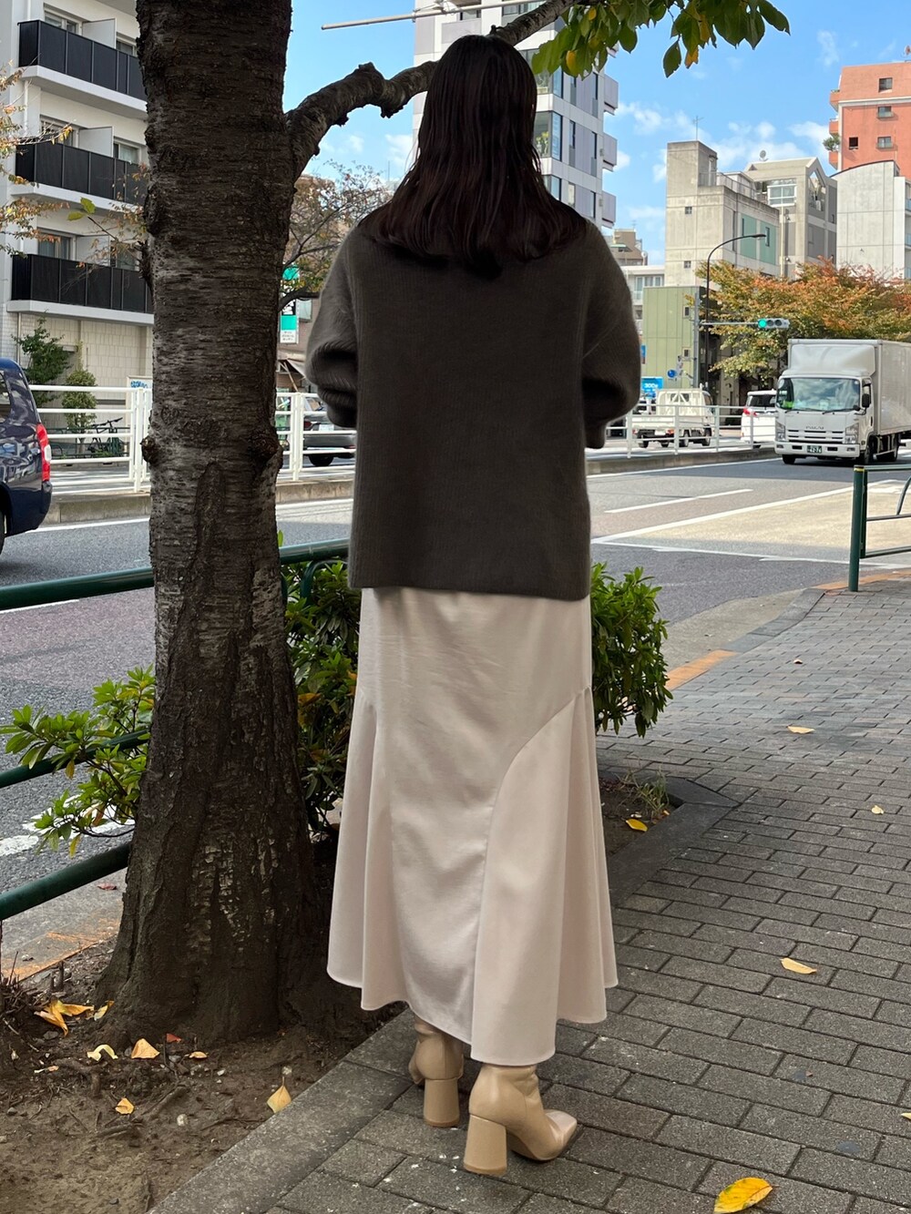 ベージュ系のニット/セーター、ベージュ系のブーツ、グレー系のスカートを着用したレディースの冬コーディネートの5枚目の写真