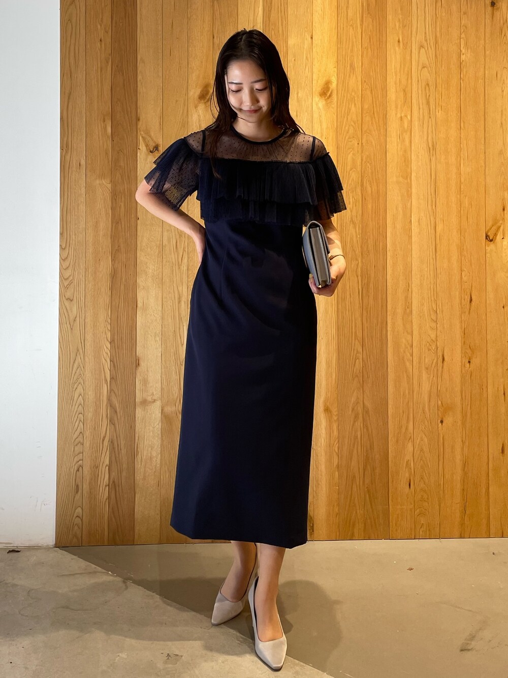 グレー系のパンプス、グレー系のクラッチバッグ、ブルー系のドレスを着用したレディースの冬コーディネートの3枚目の写真