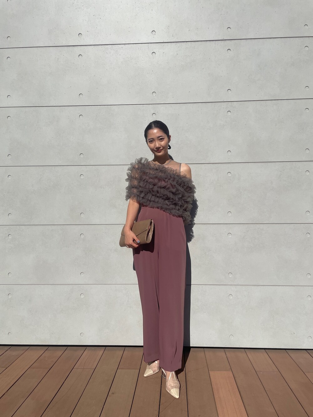 ピンク系のパンツドレス、ゴールド系のハンドバッグ、ベージュ系のパンプスを着用したレディースの秋コーディネートの8枚目の写真