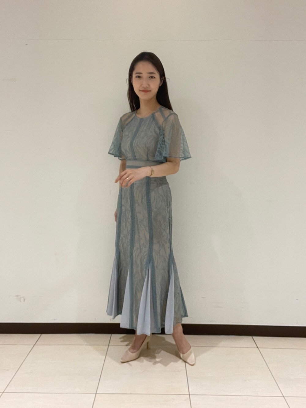 グリーン系のドレス、ベージュ系のパンプスを着用したレディースの春コーディネートの4枚目の写真