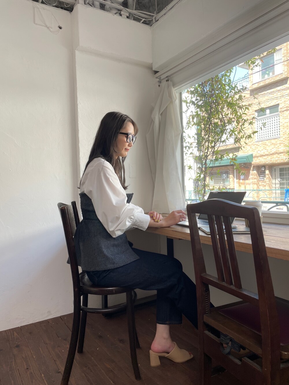 ブルー系のデニムパンツ、ブラック系のシャツ/ブラウス、ベージュ系のサンダルを着用したレディースの夏コーディネートの6枚目の写真