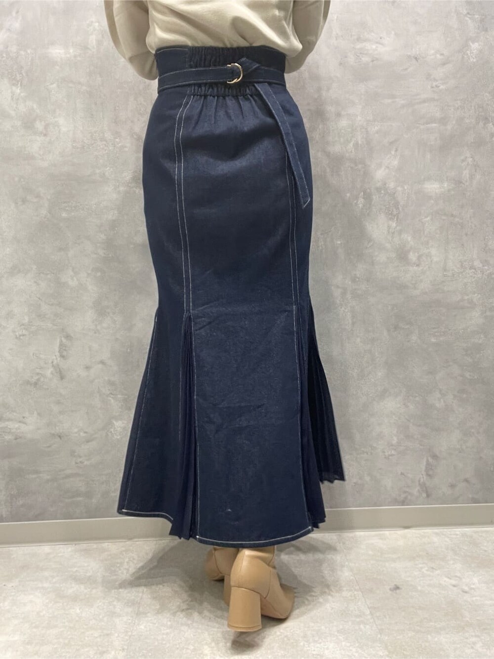 ベージュ系のブーツ、ブルー系のスカート、ホワイト系のニット/セーターを着用したレディースの秋コーディネートの8枚目の写真