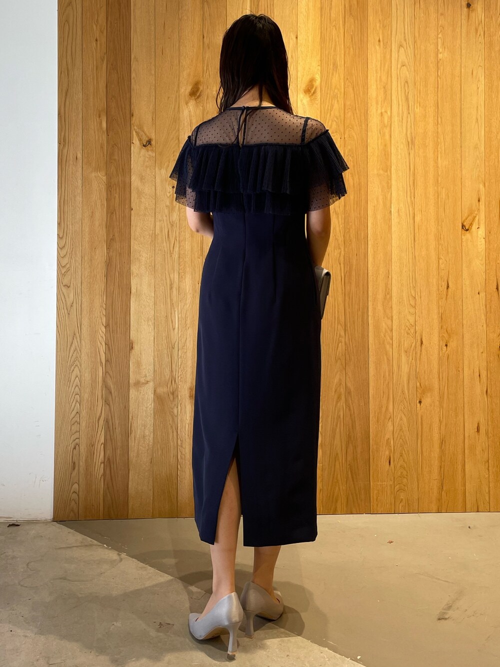 グレー系のパンプス、グレー系のクラッチバッグ、ブルー系のドレスを着用したレディースの冬コーディネートの5枚目の写真