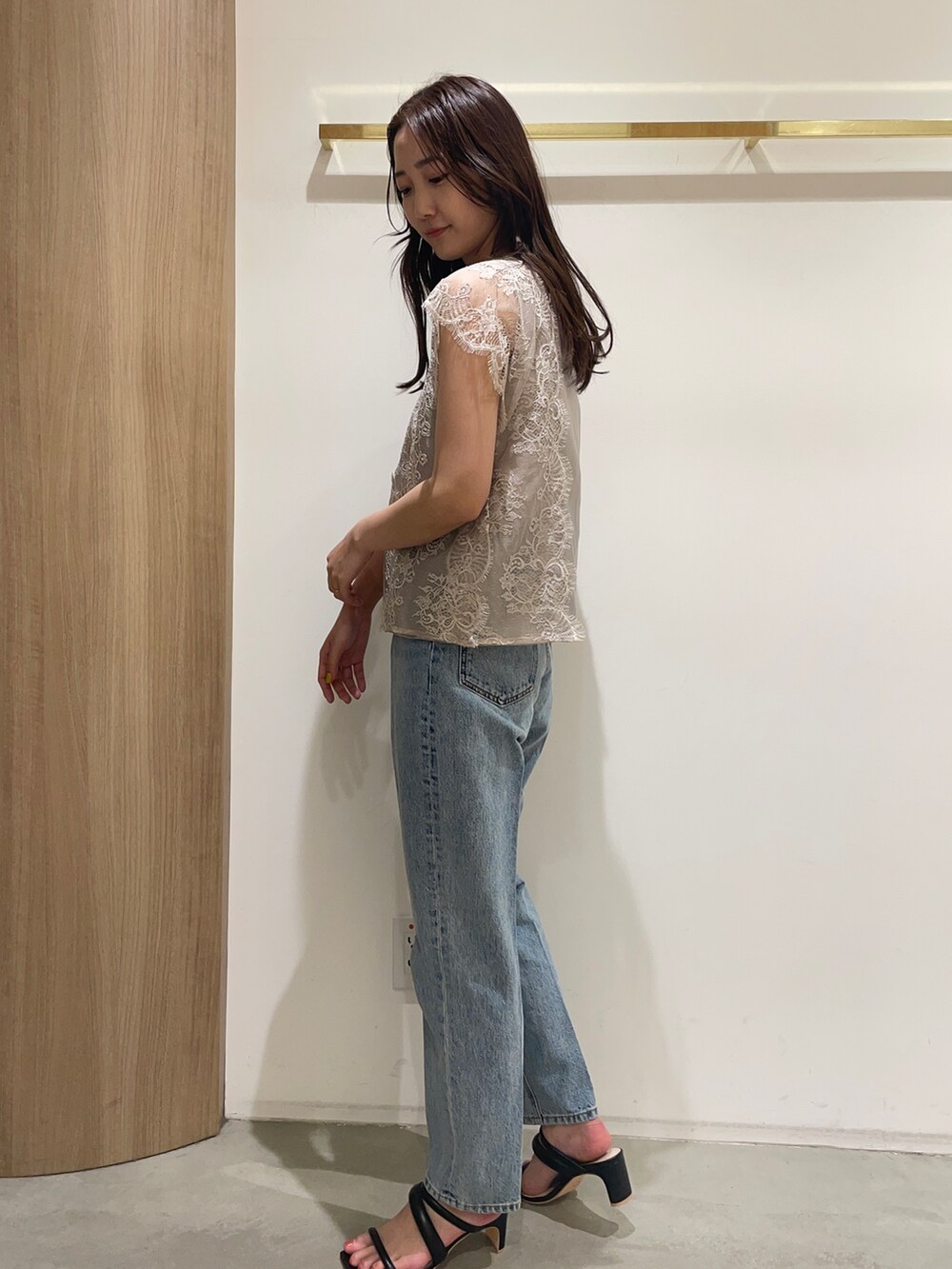 ベージュ系のシャツ/ブラウス、ブルー系のデニムパンツ、ブラック系のサンダルを着用したレディースの春コーディネートの4枚目の写真