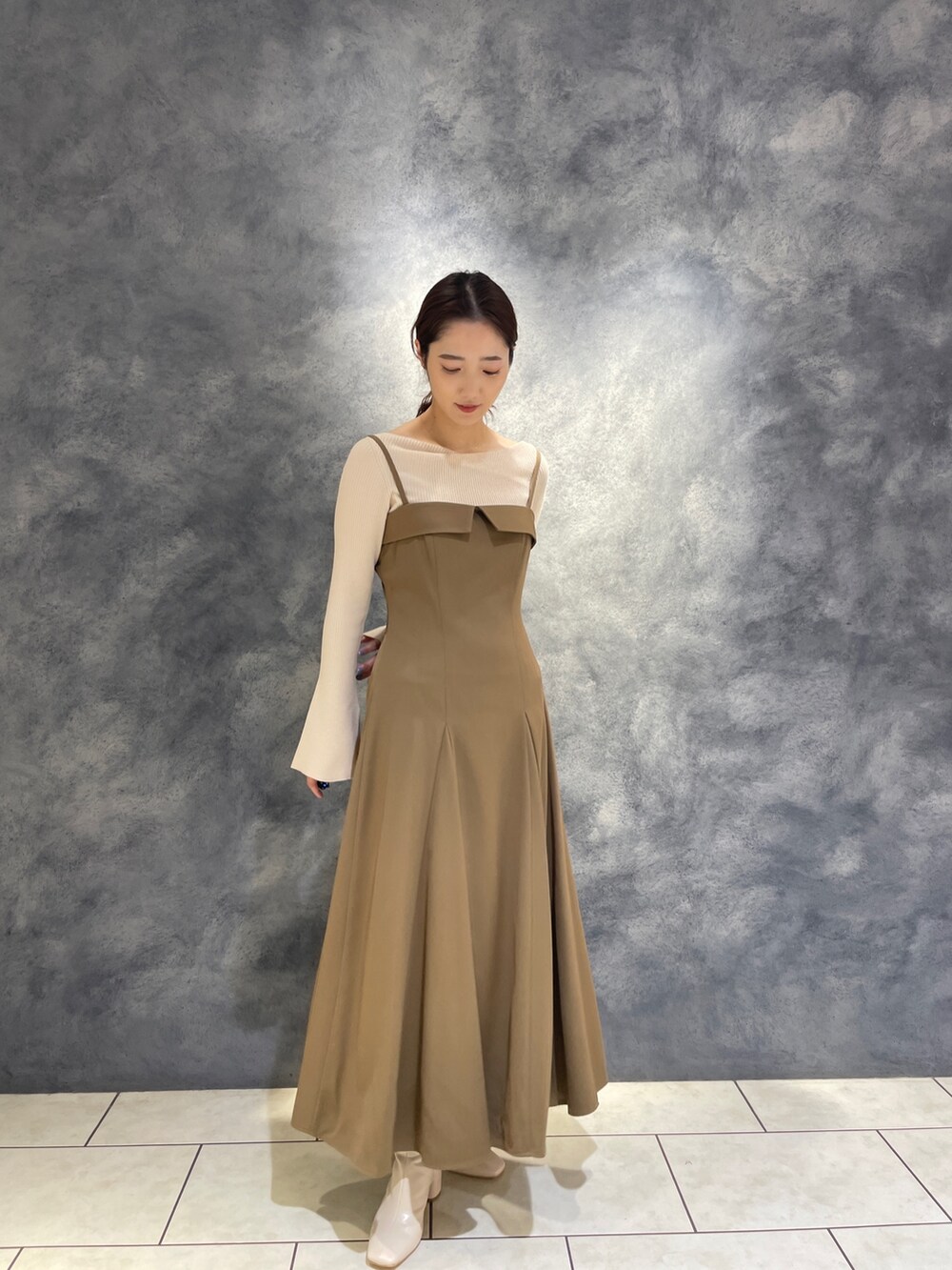 ホワイト系のニット/セーター、ベージュ系のワンピース、ホワイト系のブーツを着用したレディースの冬コーディネートの3枚目の写真