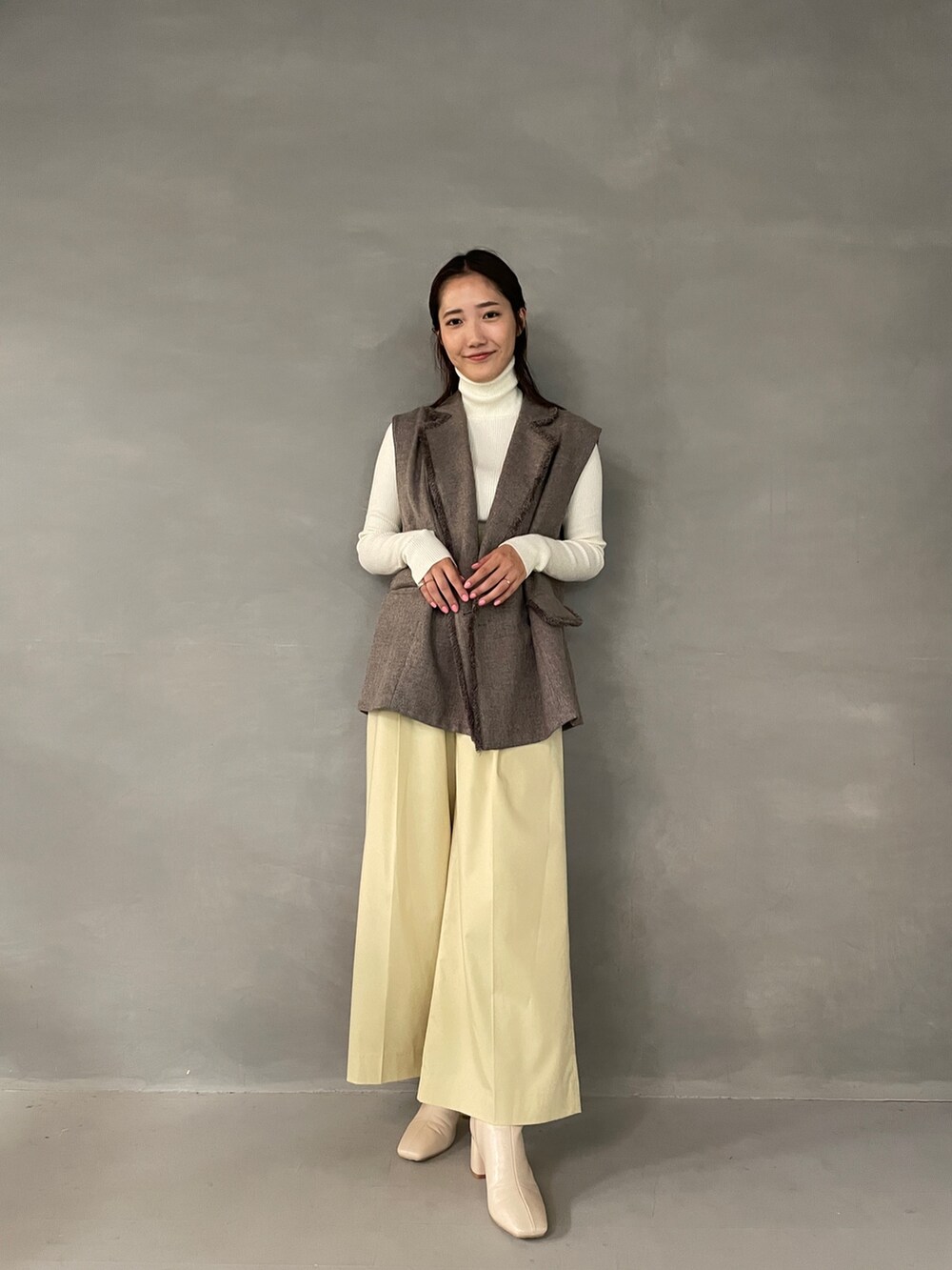 イエロー系のその他パンツ、ホワイト系のブーツ、グレー系のベストを着用したレディースの夏コーディネートの6枚目の写真