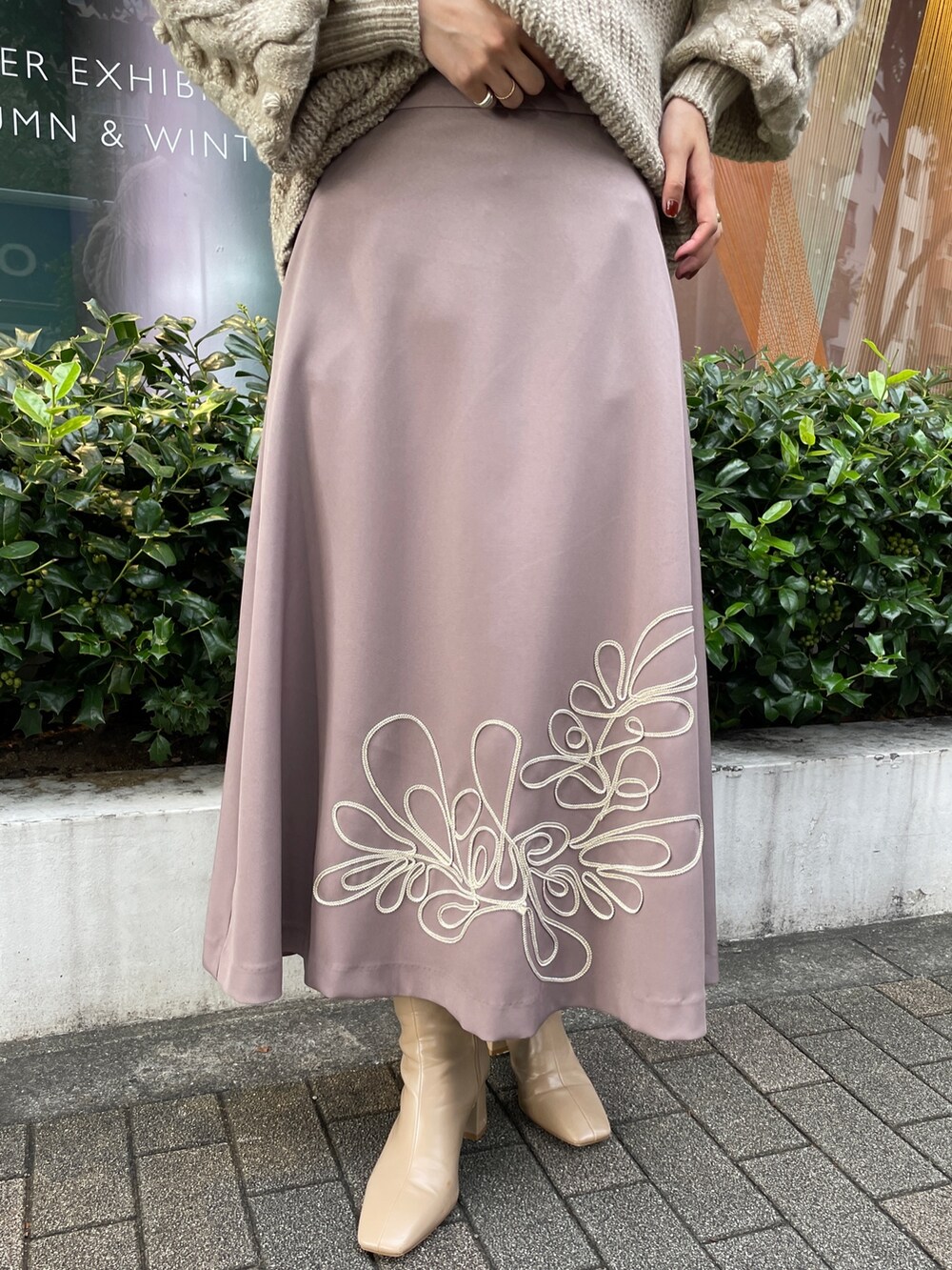 ホワイト系のニット/セーター、ホワイト系のその他アウター、ベージュ系のスカートを着用したレディースの秋コーディネートの8枚目の写真