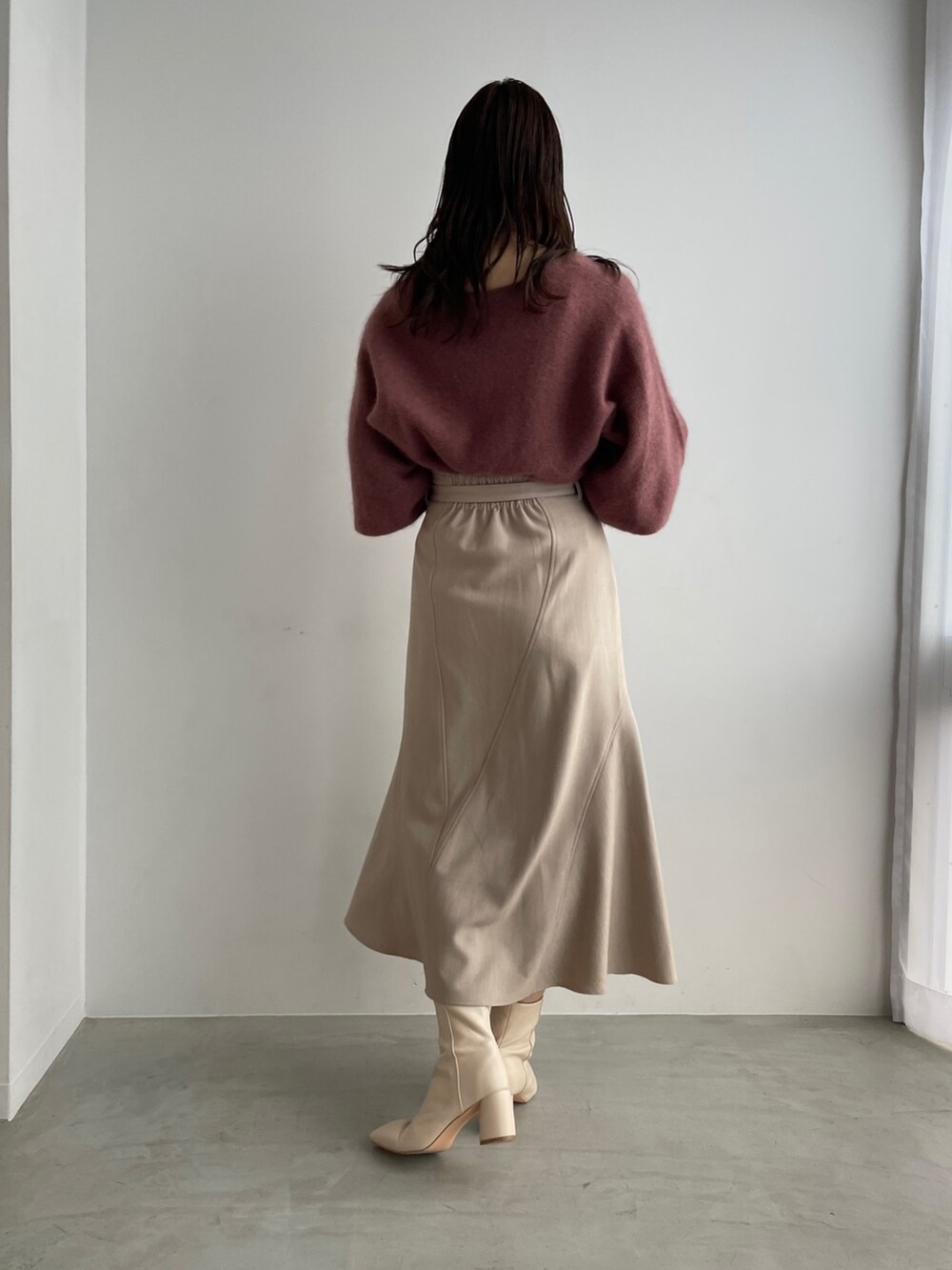 ホワイト系のブーツ、ベージュ系のスカート、ピンク系のニット/セーターを着用したレディースの夏コーディネートの3枚目の写真