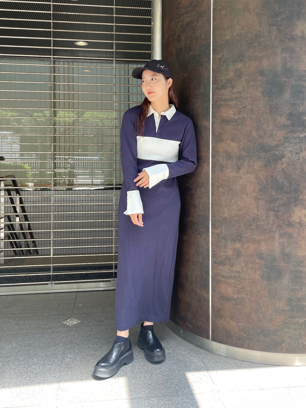 ブルー系のワンピース、ブラック系のキャップを着用したレディースの夏コーディネートの3枚目の写真