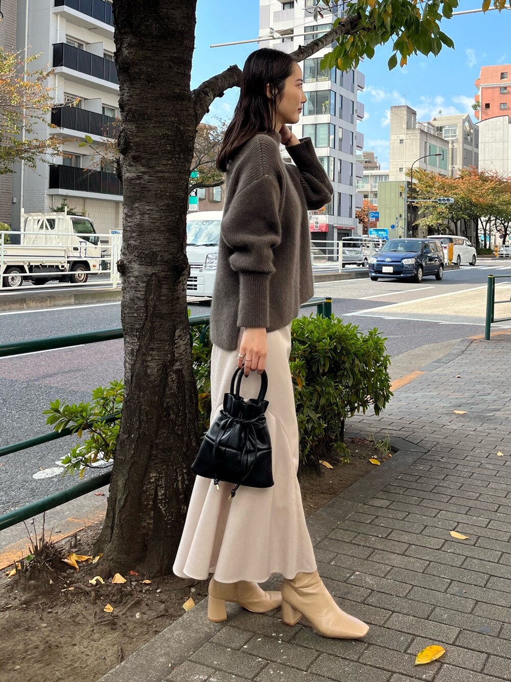 ベージュ系のニット/セーター、ベージュ系のブーツ、グレー系のスカートを着用したレディースの冬コーディネートの4枚目の写真