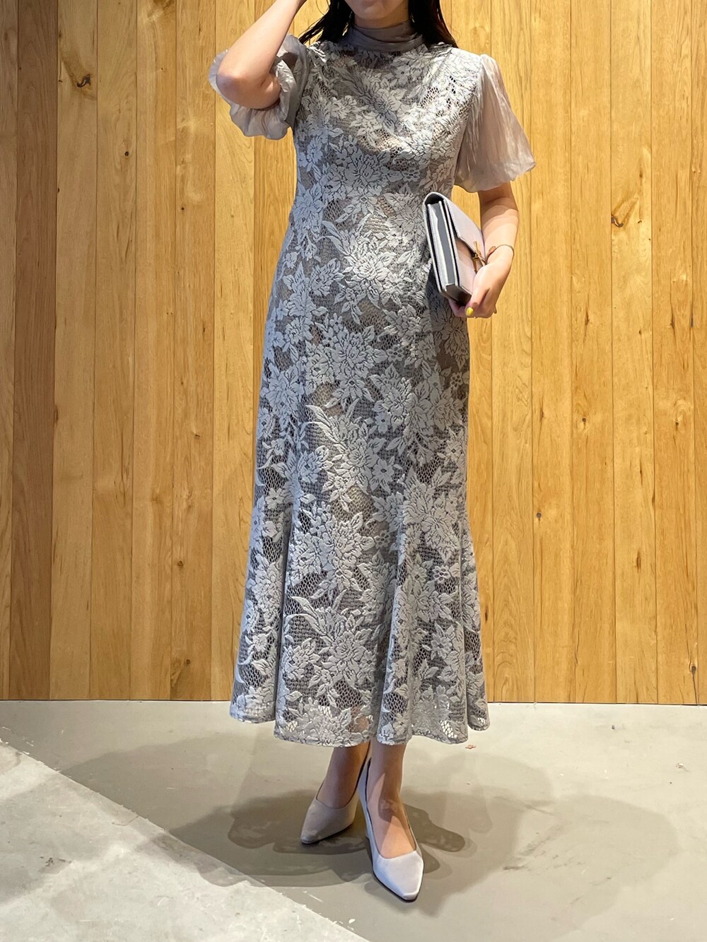 グレー系のパンプス、グレー系のクラッチバッグ、グレー系のドレスを着用したレディースの冬コーディネートの2枚目の写真