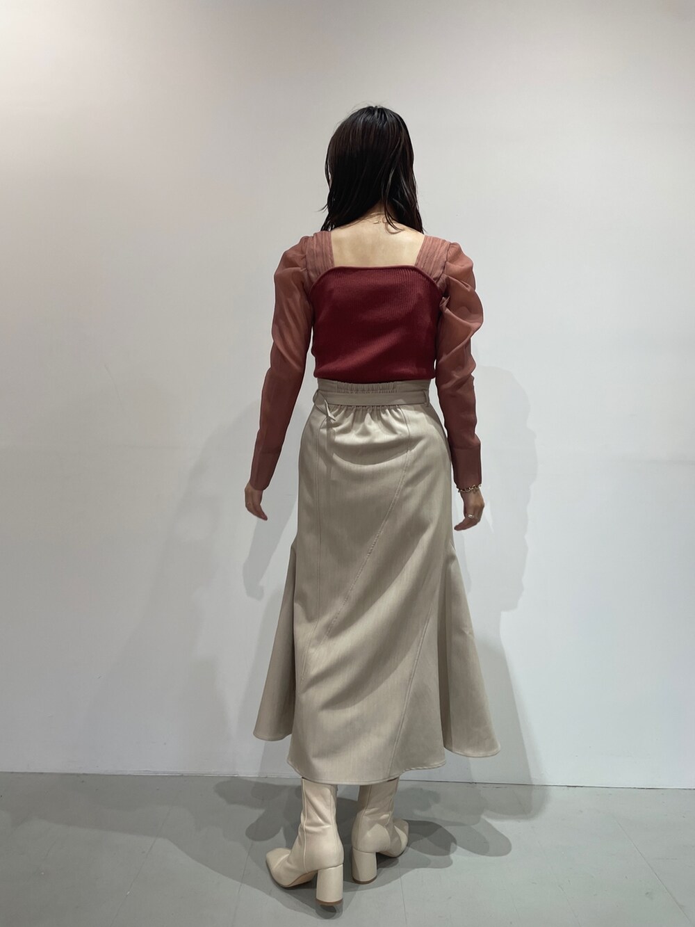 ホワイト系のブーツ、ベージュ系のスカート、ピンク系のニット/セーターを着用したレディースの夏コーディネートの6枚目の写真