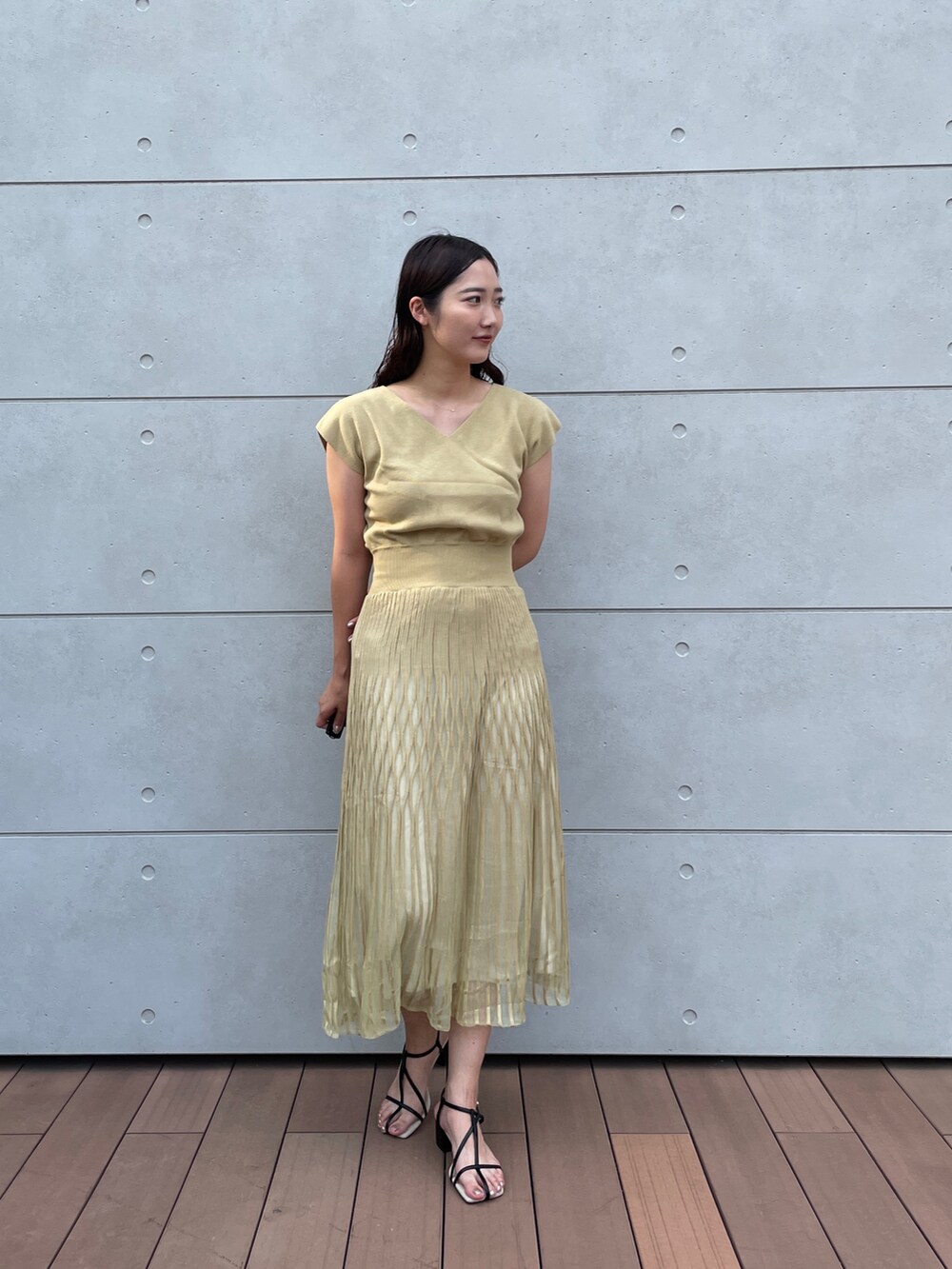 グリーン系のワンピース、ブラック系のサンダルを着用したレディースの夏コーディネートの3枚目の写真