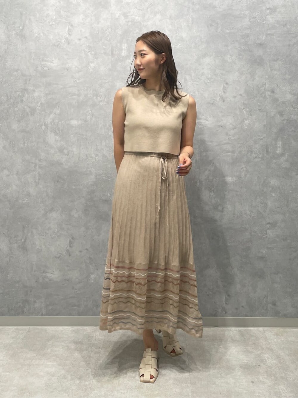 ベージュ系のワンピース、ホワイト系のサンダルを着用したレディースの夏コーディネートの2枚目の写真