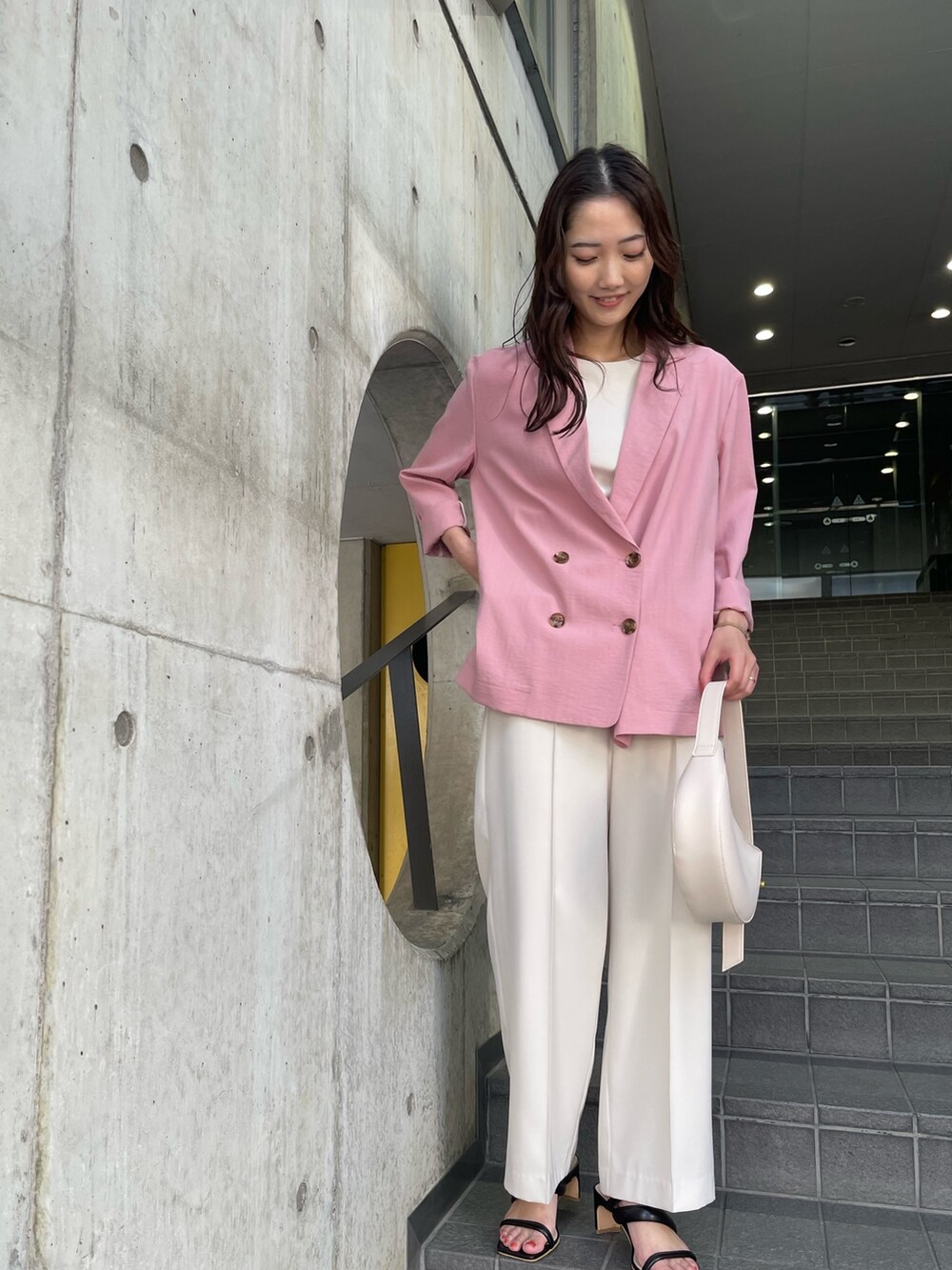 ホワイト系のその他パンツ、ピンク系のテーラードジャケット、ホワイト系のニット/セーターを着用したレディースの冬コーディネートの3枚目の写真