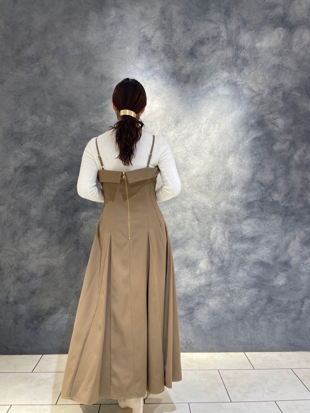 ベージュ系のワンピース、ホワイト系のニット/セーター、ホワイト系のブーツを着用したレディースの冬コーディネートの8枚目の写真