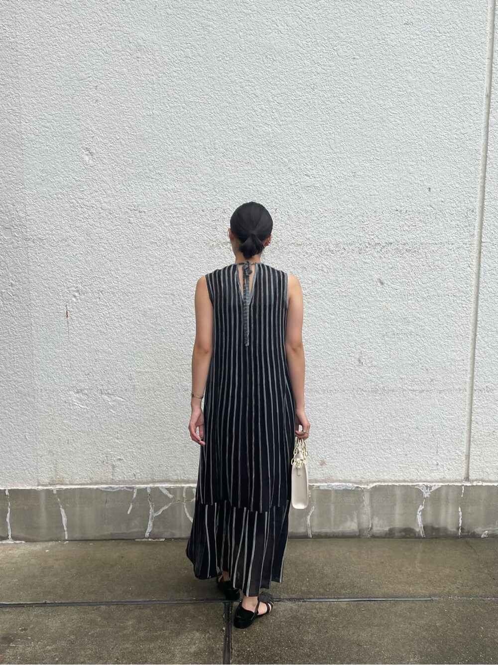 ブラック系のワンピース、ホワイト系のショルダーバッグを着用したレディースの夏コーディネートの3枚目の写真